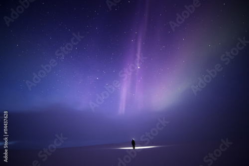 Person bathed in light from Aurora borealis, Finland photo