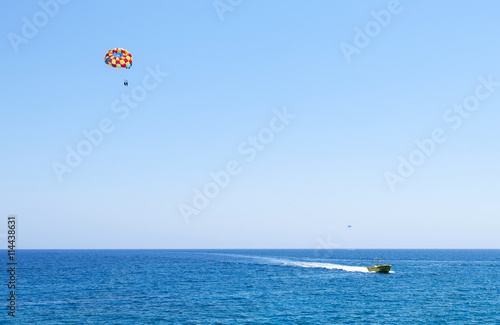 Photo of sea in protaras, cyprus island with parasailing and a boat.