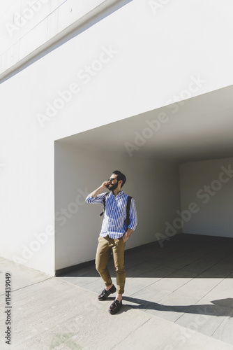 Young man with sunglasses telephoning with smartphone photo