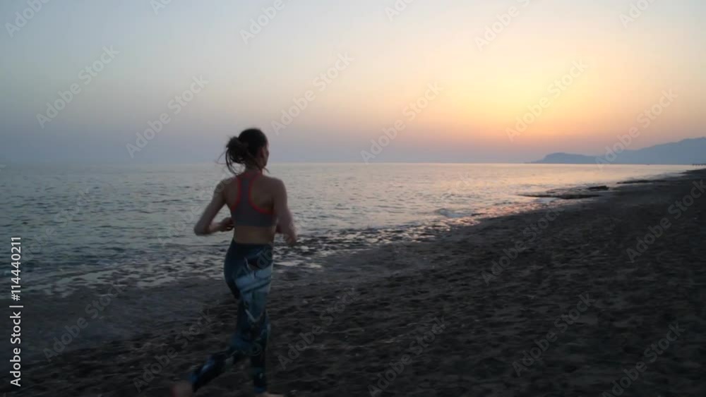 Woman running by the sea beach of Mediterranean Sea at sunset. Shot on steadycam. Camera slightly moving out. Woman running by the sea beach of Mediterranean Sea at sunset. Shot on steadycam. Camera slightly moving out.