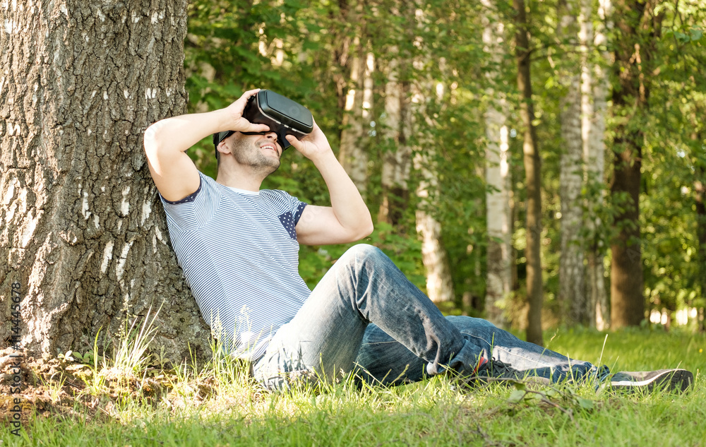 Man wearing virtual reality headset in park Man wearing virtual reality headset in park