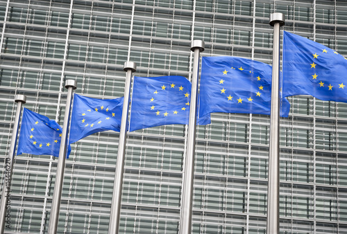 Row of EU European Union flags flying in front of administrative building at the EU headquarters in Brussels, Belgium