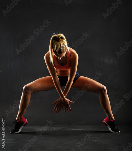 Fitness female woman with muscular body, doing her workout