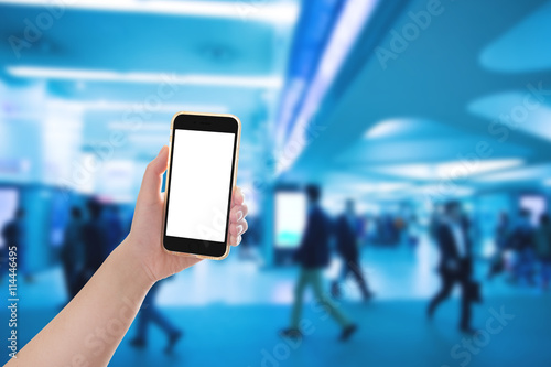 Hand holding mobile phone with blur crowd background