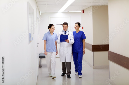 group of smiling medics at hospital with clipboard