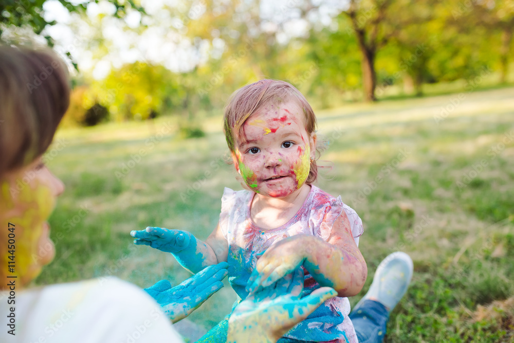 Family playing in the park. Family painted in the colors of Holi Family playing in the park. Family painted in the colors of Holi