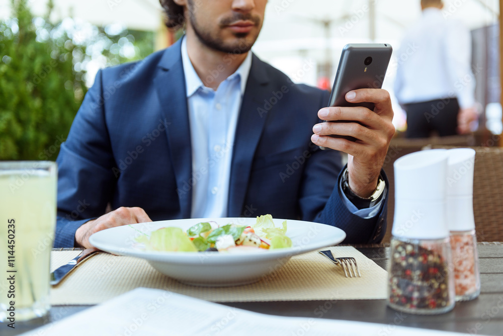 Busy man messaging on telephone in restaurant Busy man messaging on telephone in restaurant