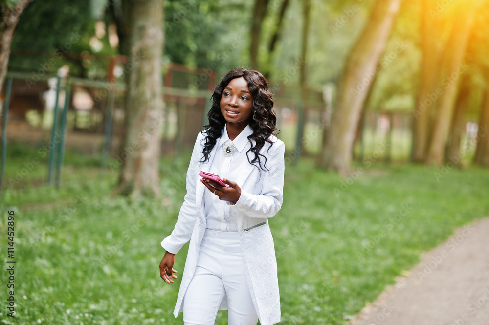 Stylish black african american girl walking on park with mobile Stylish black african american girl walking on park with mobile