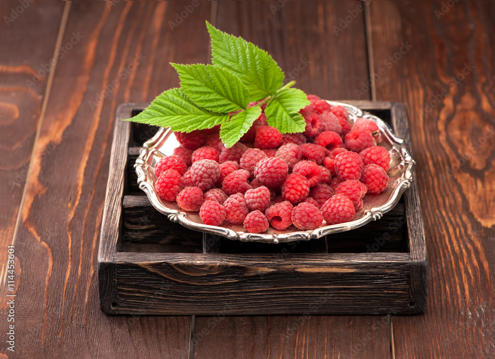 Fresh raspberries in a silver plate on a rustic background Fresh raspberries in a silver plate on a rustic background