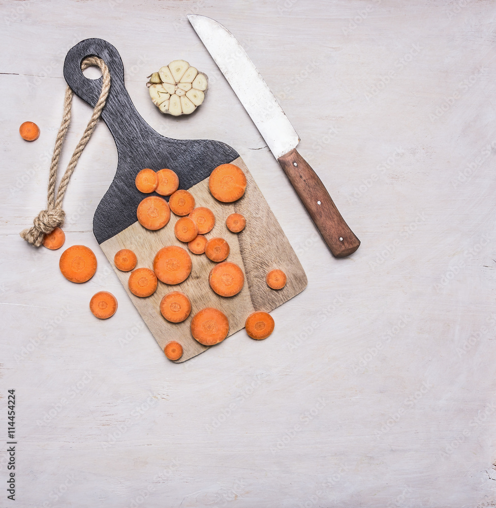 vegetarian food, sliced carrot slices on a wooden cutting board with a knife place for text vegetarian food, sliced carrot slices on a wooden cutting board with a knife place for text