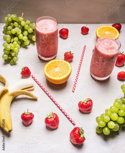 Healthy fruits smoothies with colorful ingredients on white wooden background, top view, place for text. Superfoods and healthy lifestyle or detox diet food concept