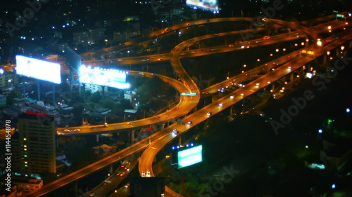 FullHD video - Wide, curving, well-lit ramps of a major highway interchange in downtown Bangkok at night, with light traffic. photo