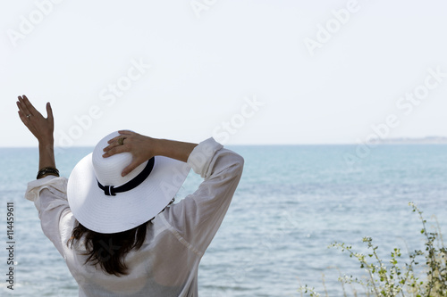 girl waving in front of the sea