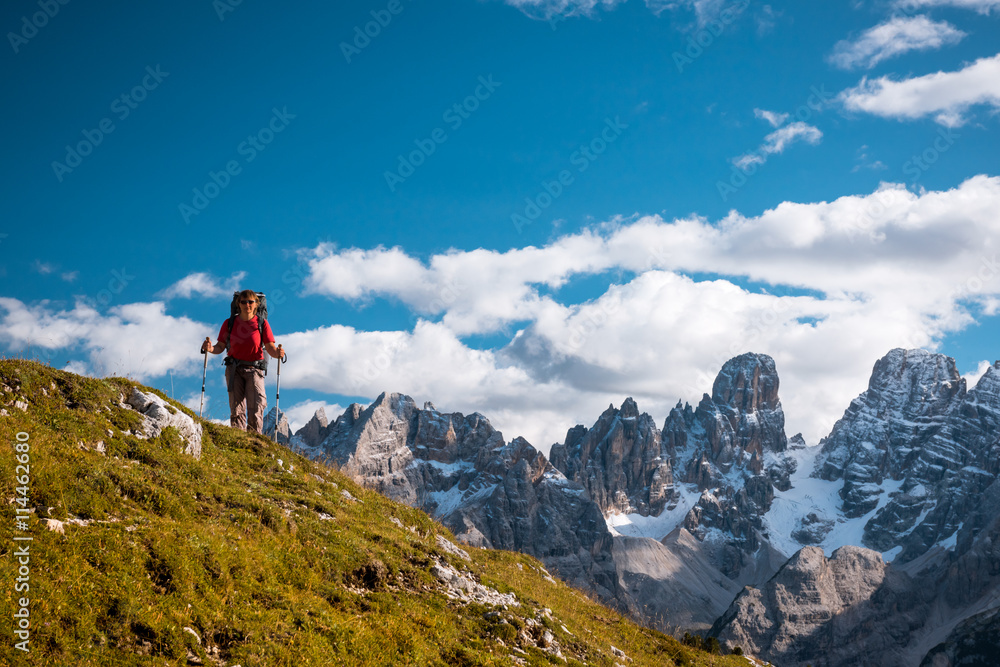 hiker with backpack standing on path in mountains