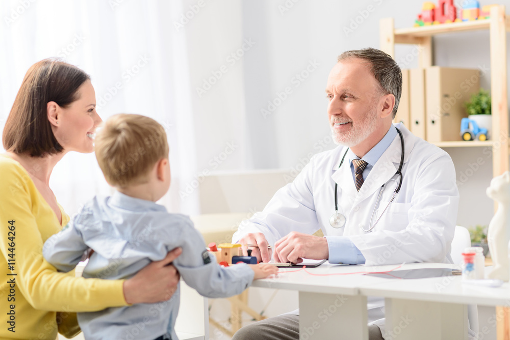 Fototapeta premium Little boy with his mother at paediatrician on consultation