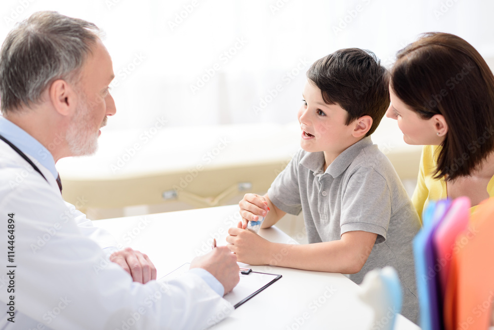 Fototapeta premium Mature pediatrician making recommendations for small patient