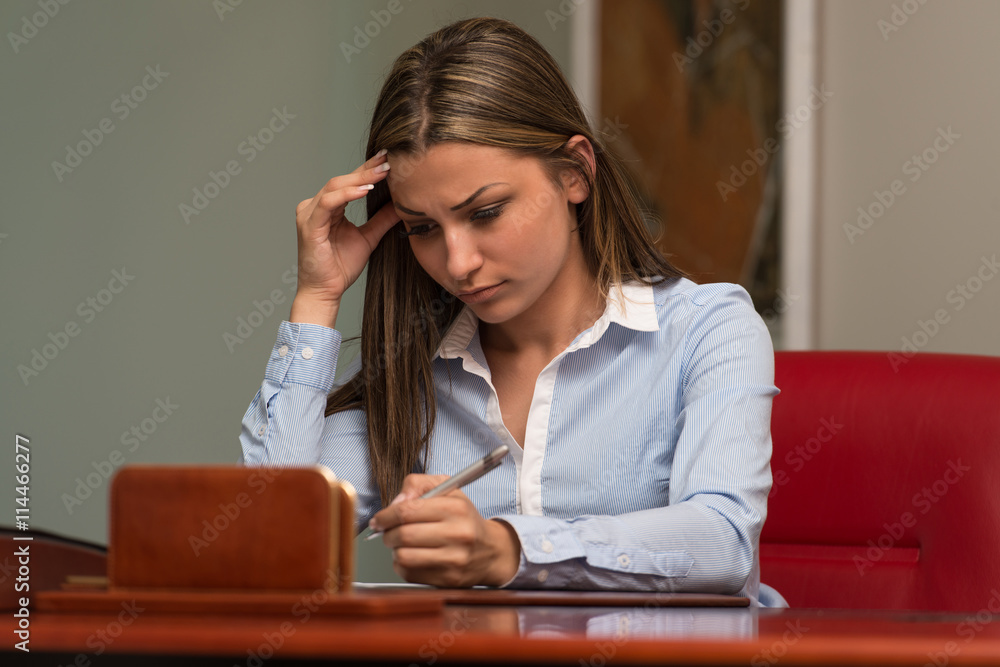 Overworked Businesswoman Sitting By Her Desk Overworked Businesswoman Sitting By Her Desk