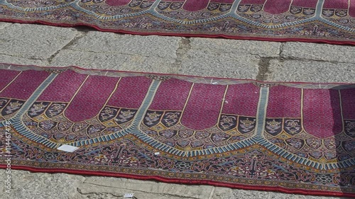 Beautiful praying carpets drying in the sun at the inner courtyard of the Jameh Mosque, oldest mosque in Isfahan Iran.