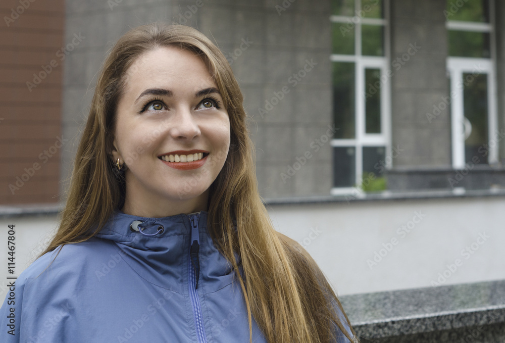  Young woman looking happily at a new building