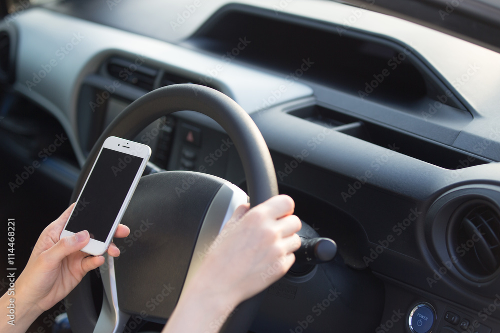 運転しながらスマホを触る女性