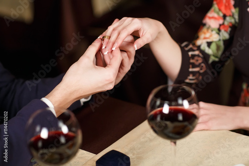 Young Man puts the ring on the finger of his girlfriend.