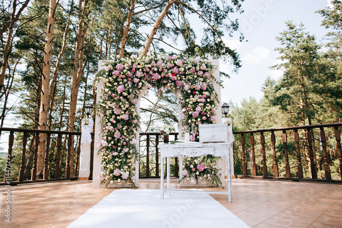 arch for the wedding ceremony, decorated with fresh flowers in a pine forest