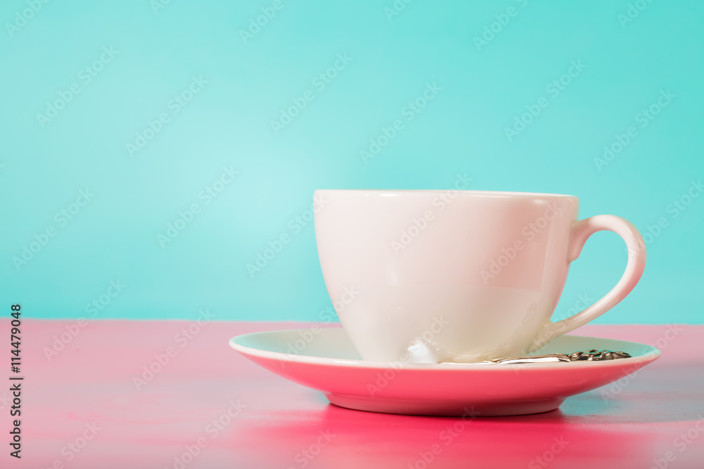White coffee mug on bright pink and blue background White coffee mug on bright pink and blue background