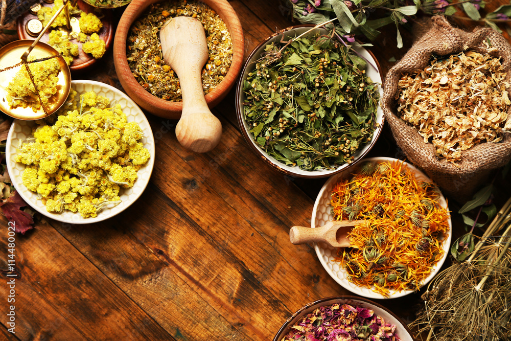 Assortment of dry medicinal herbs in bowls on wooden background top view Assortment of dry medicinal herbs in bowls on wooden background top view