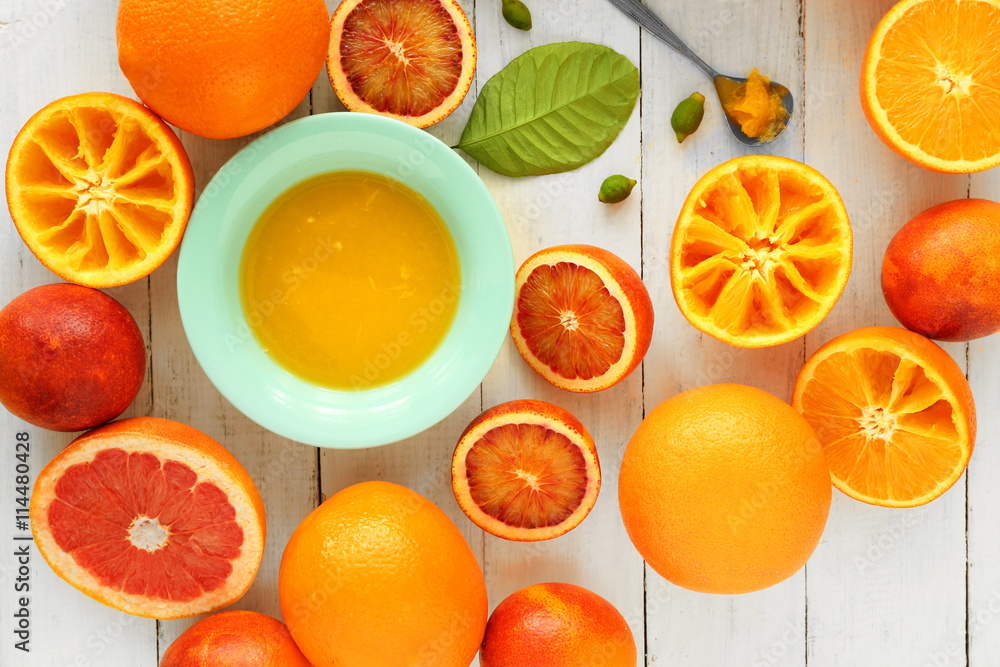 Juicing delicious oranges on white wooden table Juicing delicious oranges on white wooden table