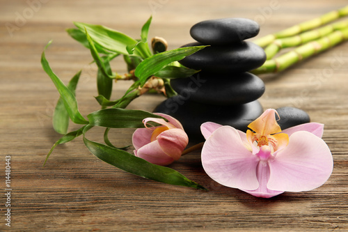 Spa stones  bamboo sticks and orchid flowers on wooden background