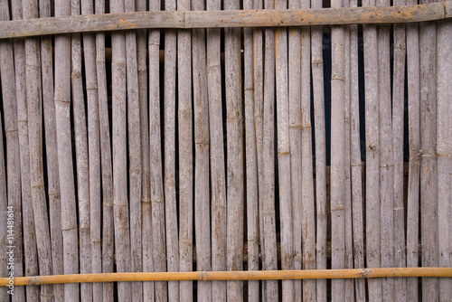 A line of yellow bamboo wall that fade and age by time.