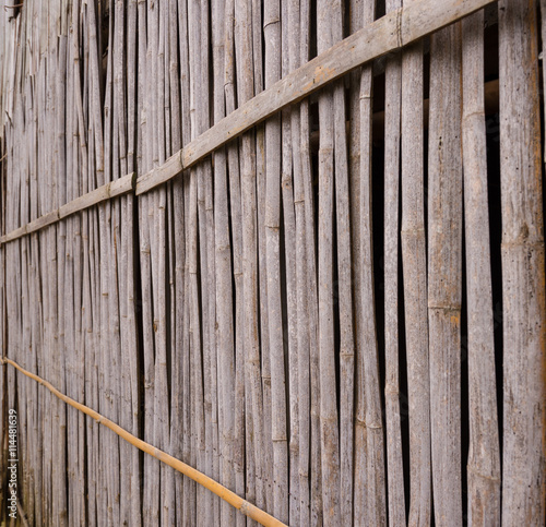 A line of yellow bamboo wall that fade and age by time.