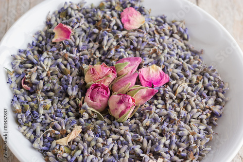 White bowl with pink dried roses and lavender flavers photo