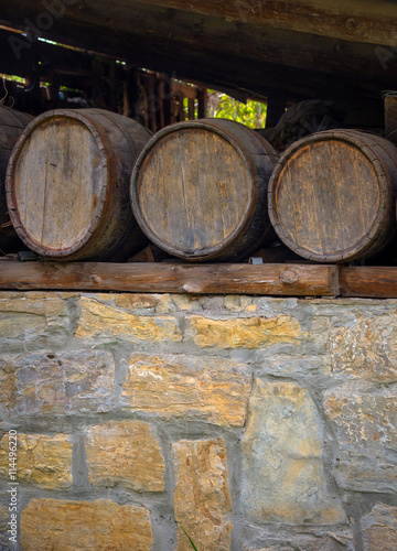 Old wine barrels on stone wall © Alexey Antipov