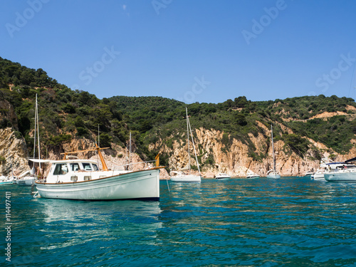Vistas de barcos en la costa con el mar transparente de tonalidades azules y verdes de la Costa Brava en verano de 2016