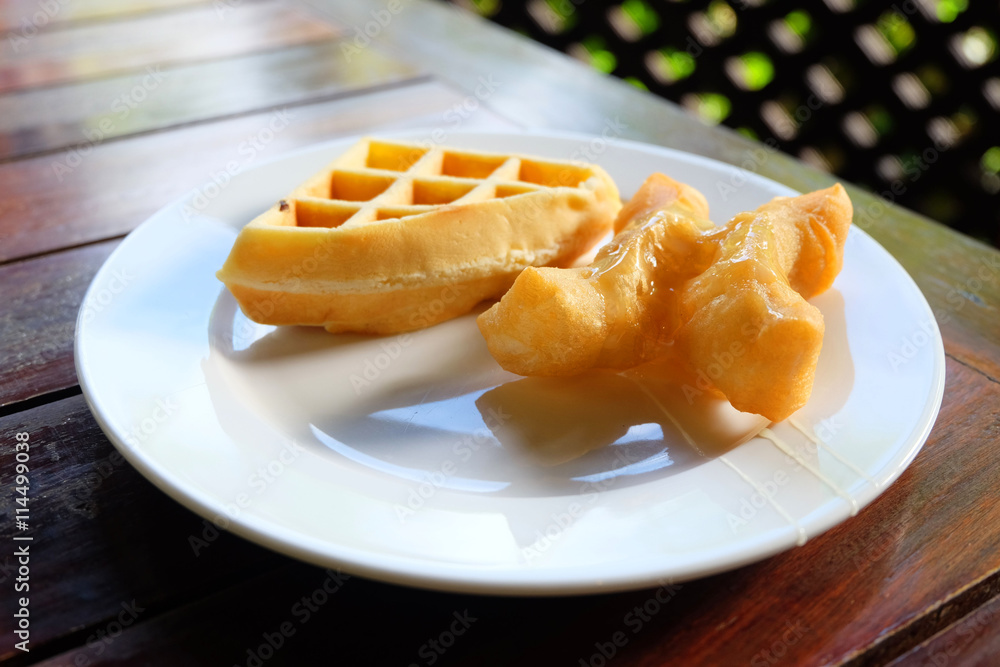waffle and deep-fried doughstick on the plate in the table waffle and deep-fried doughstick on the plate in the table