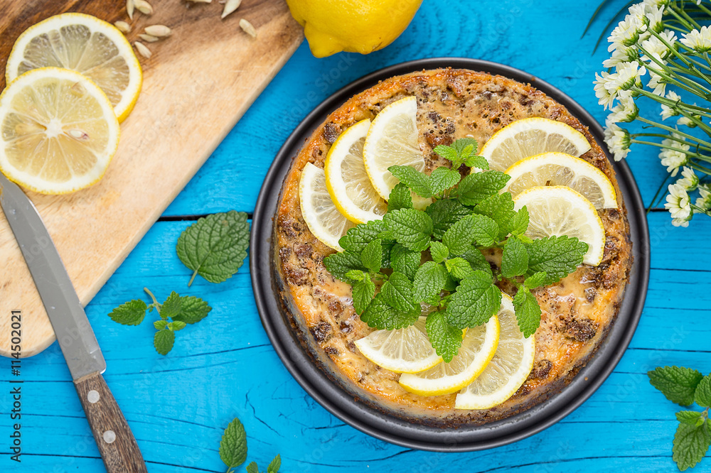 Healthy Paleo Dairy-Free Lemon Mint Cheesecake from Coconut Milk and Gluten-Free Cookies on Blue Wooden Background, Top View Healthy Paleo Dairy-Free Lemon Mint Cheesecake from Coconut Milk and Gluten-Free Cookies on Blue Wooden Background, Top View