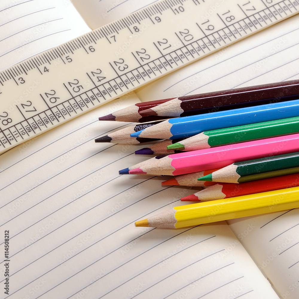 Crayons, a ruler and Notepad closeup Crayons, a ruler and Notepad closeup