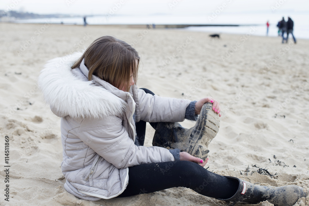 Young Girl Taking Off Wellington Boots For Walk On Beach Stock Photo |  Adobe Stock