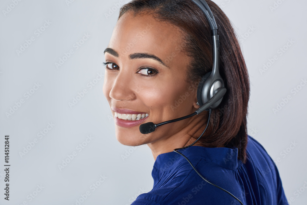 Friendly pretty mixed race woman on the phone headset smiling Friendly pretty mixed race woman on the phone headset smiling