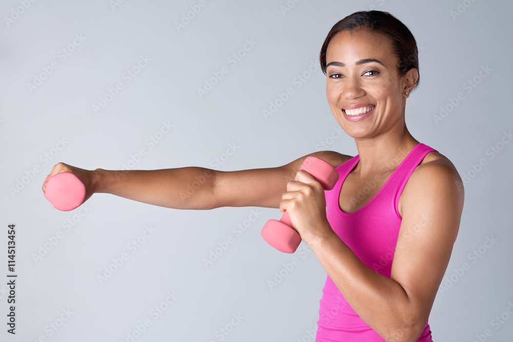 Happy smiling woman exercising with dumbbells in studio Happy smiling woman exercising with dumbbells in studio