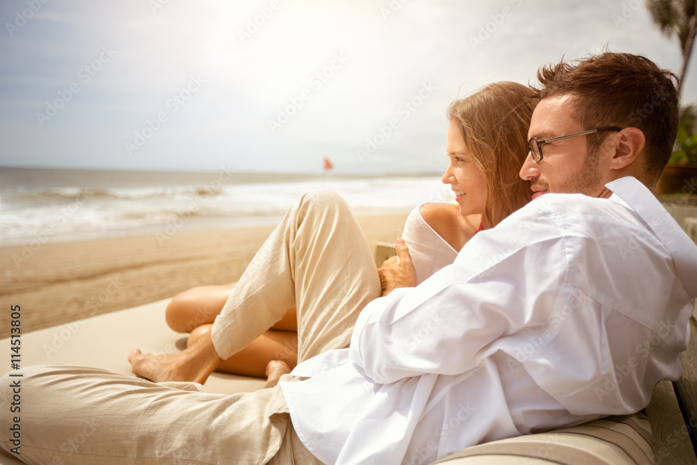 Young couple enjoying on beach - obrazy, fototapety, plakaty 