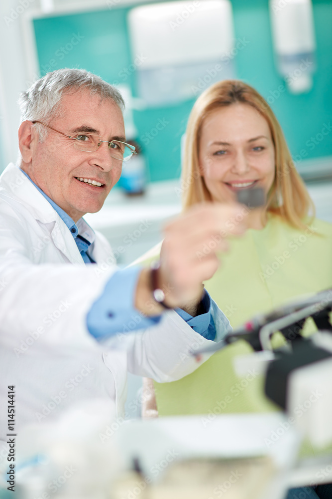 Fototapeta premium Dentist with female patient look at dental snapshot