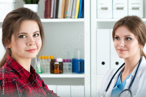 Smiling female patient sitting at medicine doctor office