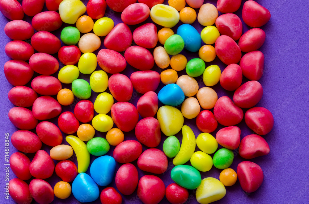 Multicolored candies on purple background Multicolored candies on purple background