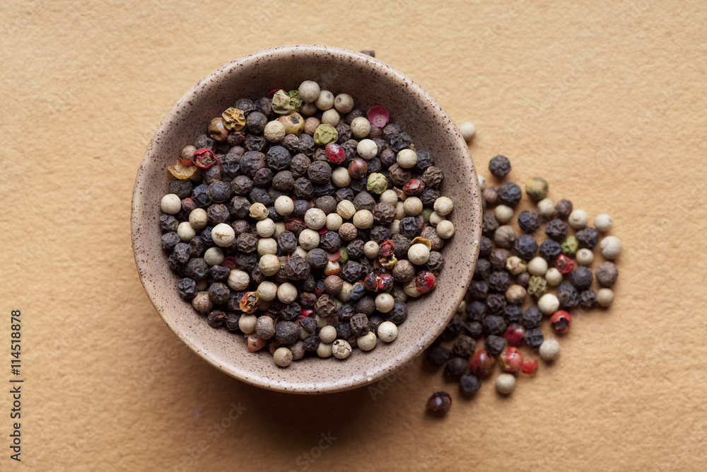 Mix of pepper in bowl on paper background Mix of pepper in bowl on paper background