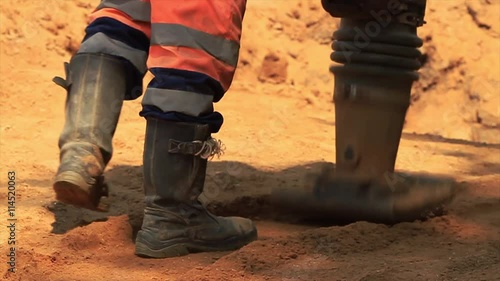 Vibratory rammer in action on a construction site.