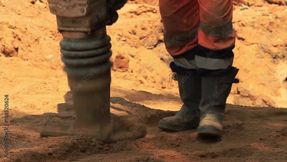 Vibratory rammer in action on a construction site. Vibratory rammer in action on a construction site.