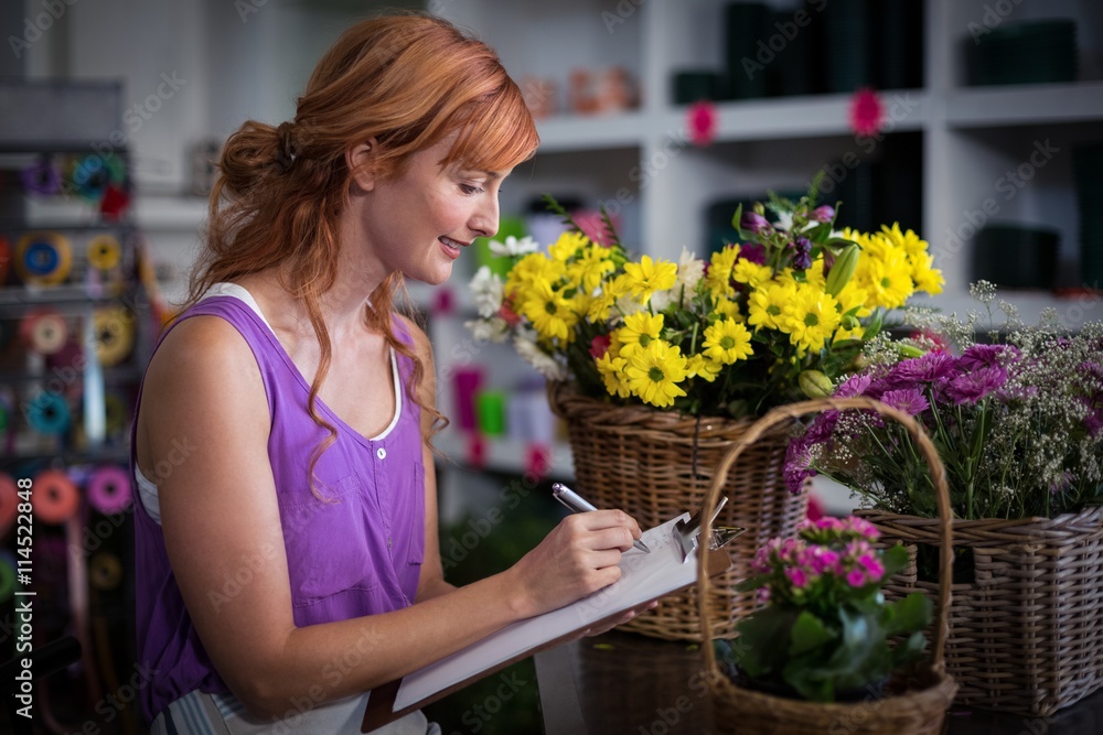 Female florist writing on the clipboard