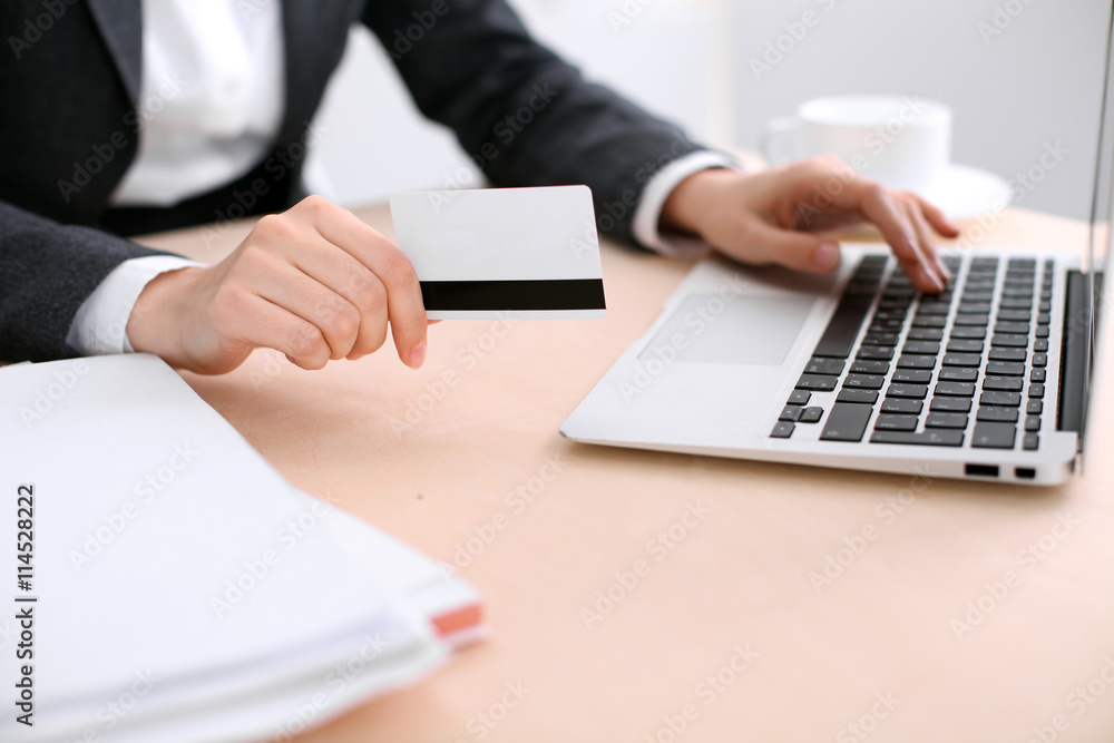 Close up of business woman hands using credit card and laptop computer Close up of business woman hands using credit card and laptop computer